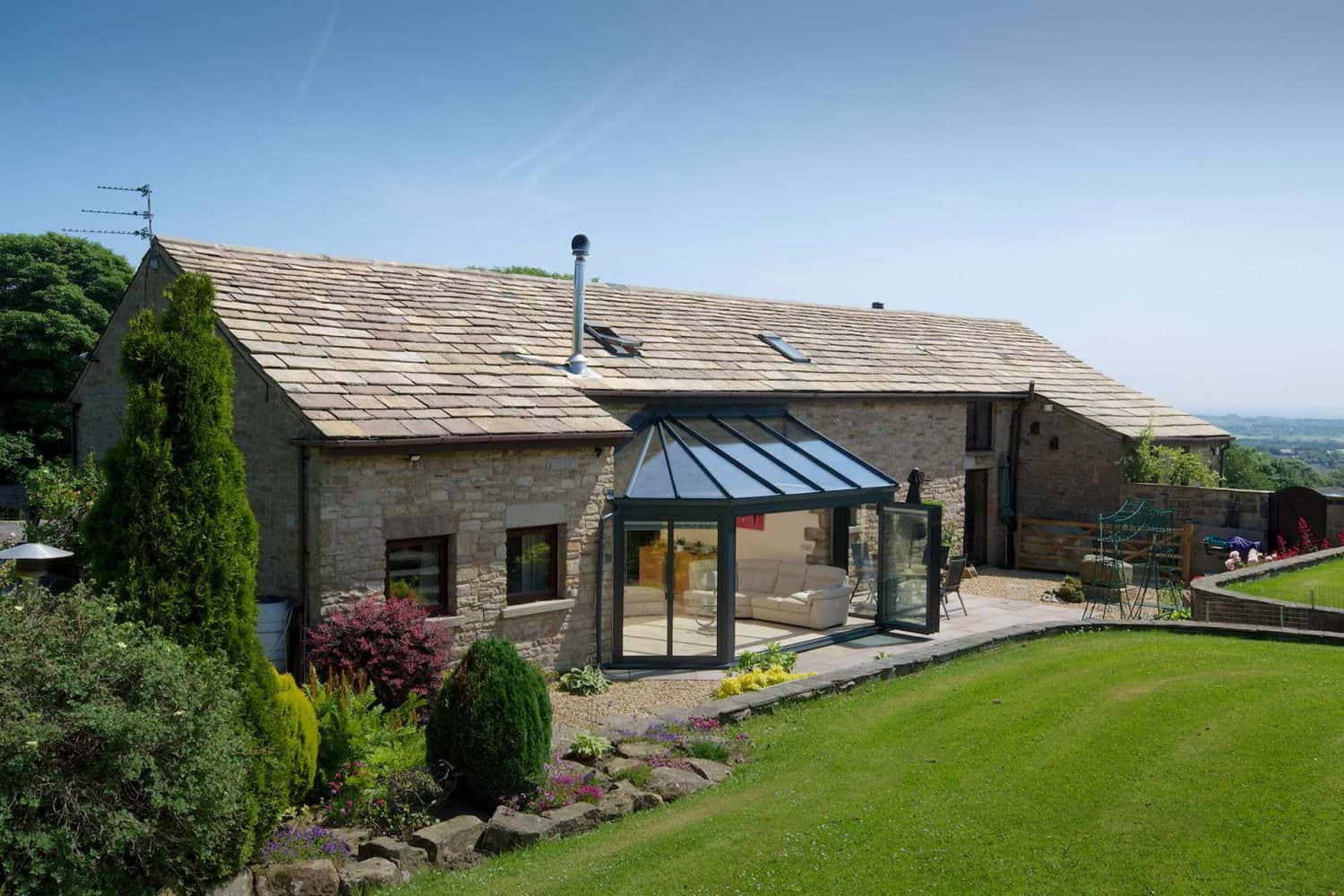 Country home set by large healthy lawn with aluminium conservatory
