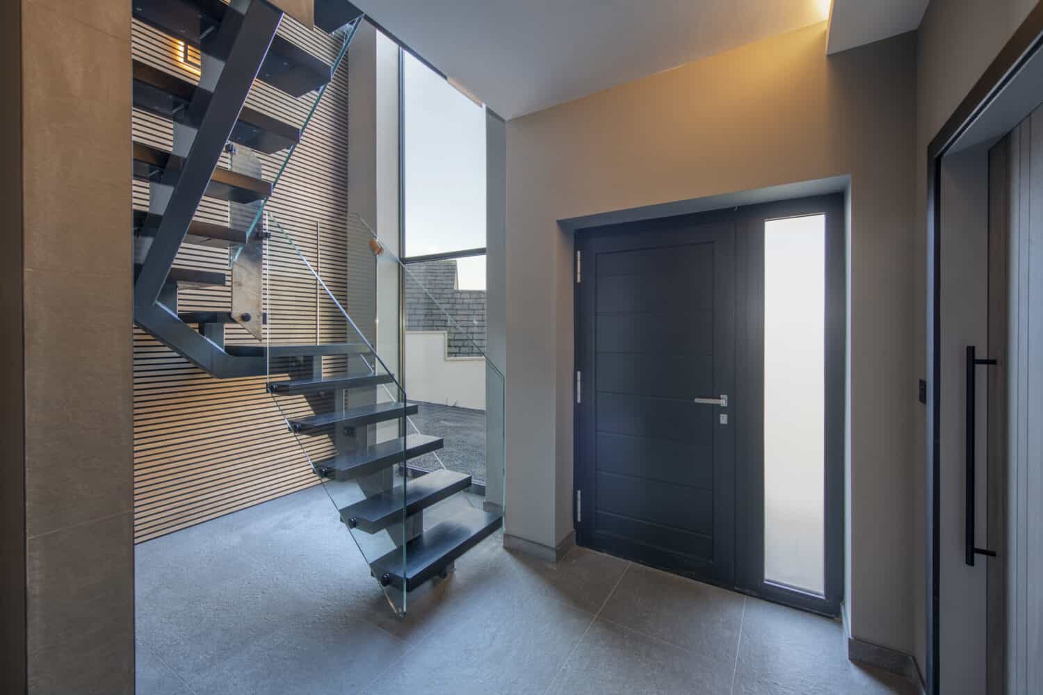 aluminium front door leading into a modern staircase