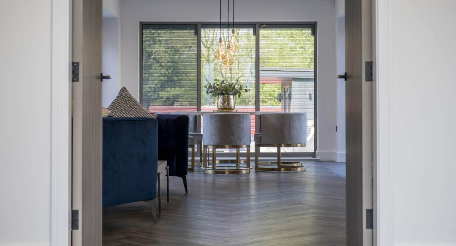 Open interior bifold doors with a view to a dining area which is featuring sliding doors
