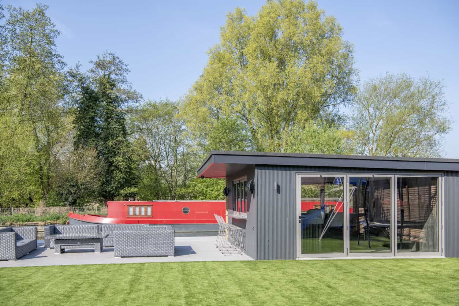Black garden room with aluminum grey bifold doors and a bar area