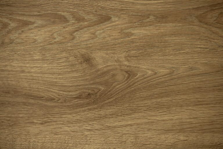 Close-up of a wooden surface with natural grain patterns and a light brown color, showcasing wavy lines—an ideal complement to bespoke glass solutions like bifold doors or glass roofing in modern interiors.