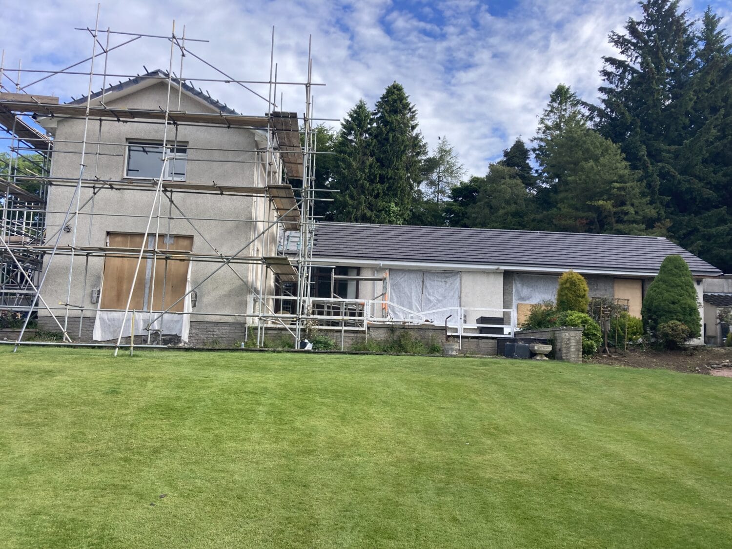 New garden house in Aberdeen featuring large bi-folding doors for seamless indoor-outdoor living, with ongoing construction and scaffolding visible.