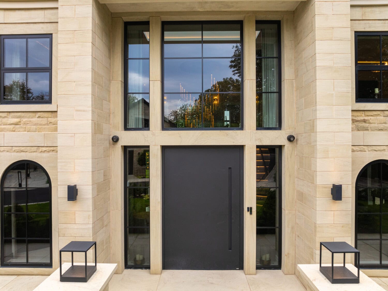 Stylish black pivot door installed in a contemporary building entrance, featuring large glass panels and a sleek design that enhances curb appeal and provides secure access.