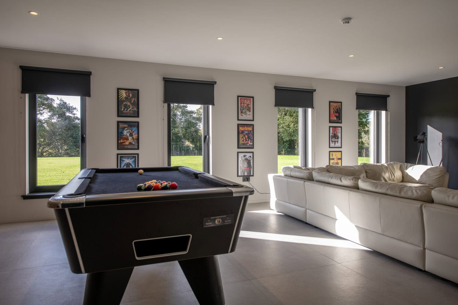 Stylish lounge featuring large bi-folding doors opening to the garden, with a pool table and contemporary decor, perfect for indoor-outdoor living at Orchard Farm, Crossford.