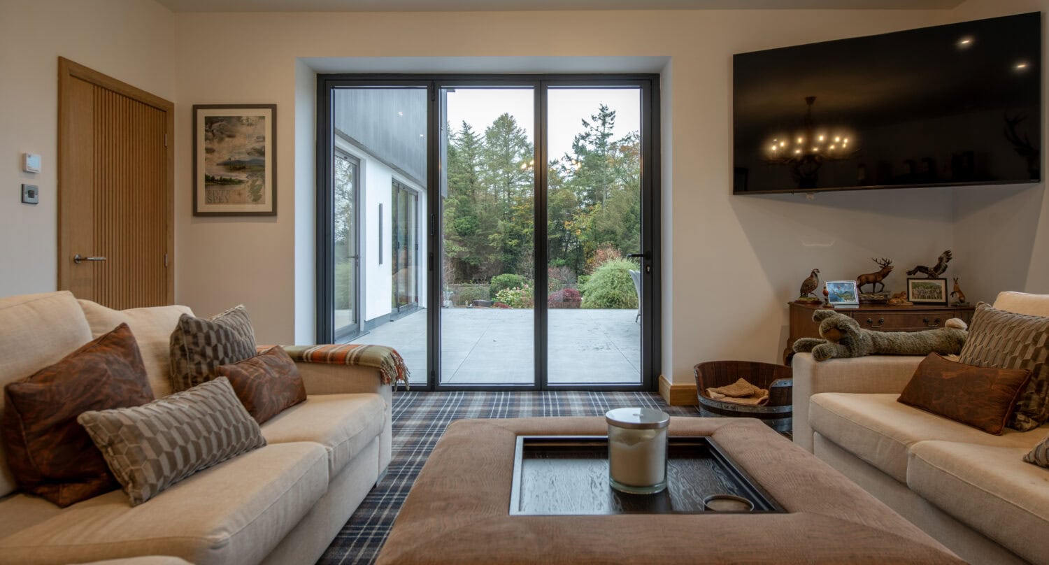 Bi-Folding doors opening to a garden patio, enhancing indoor-outdoor living with stylish, energy-efficient design. Perfect for connecting your home to outdoor spaces.
