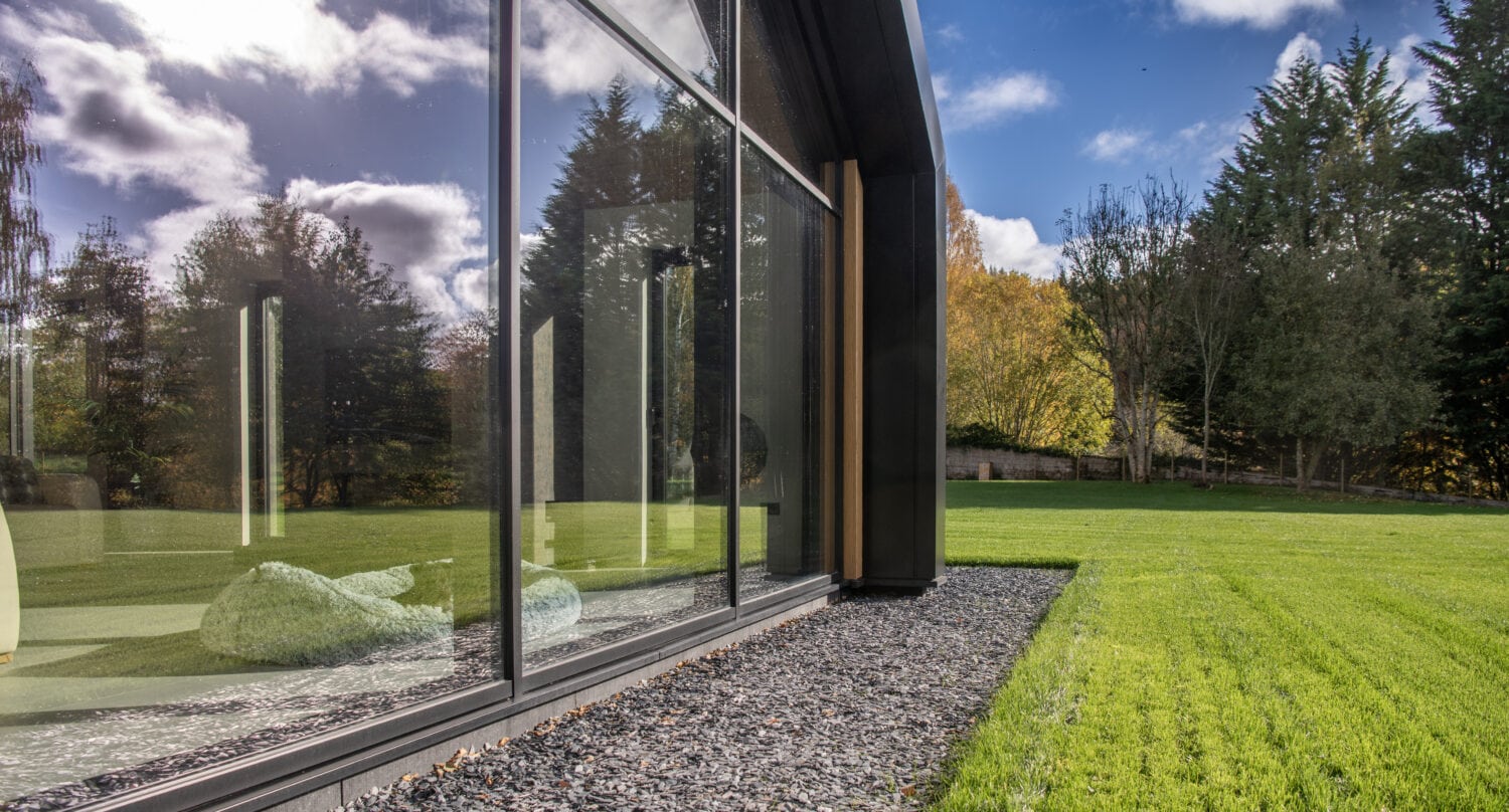 High-quality bi-folding doors at Orchard Farm, Crossford, showcasing sleek glass panels and contemporary design for seamless indoor-outdoor living.