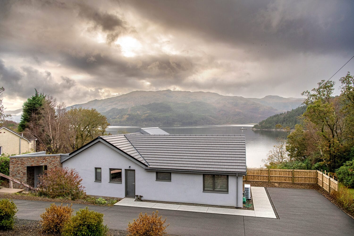 Elegant bi-folding doors at Norse Lodge, Helensburgh, offering seamless indoor-outdoor living and stunning views of the surrounding landscape.