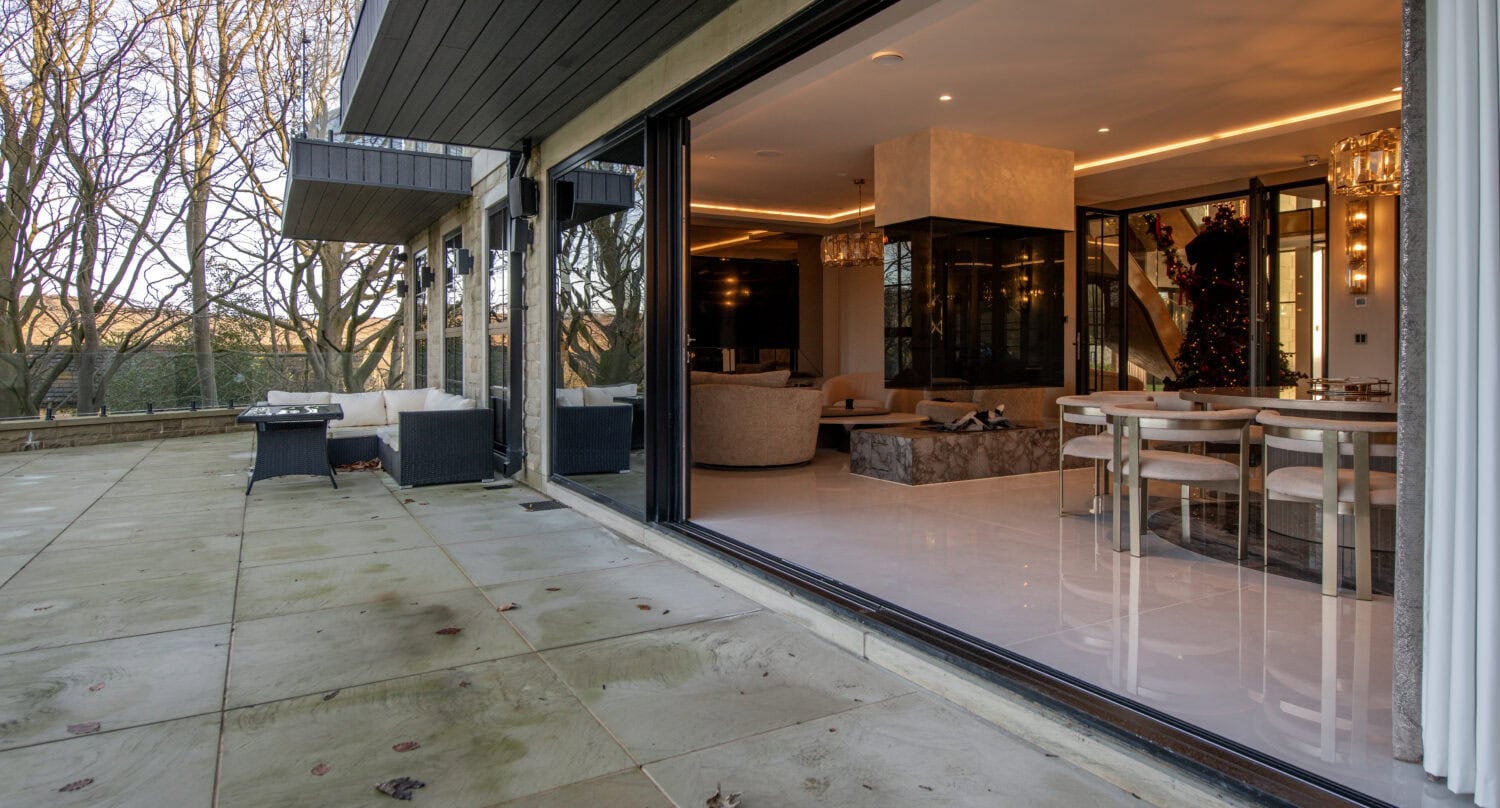 Elegant XP Glide bi-fold doors opening to a spacious outdoor patio. Perfect for seamless indoor-outdoor living with smooth operation and contemporary design.