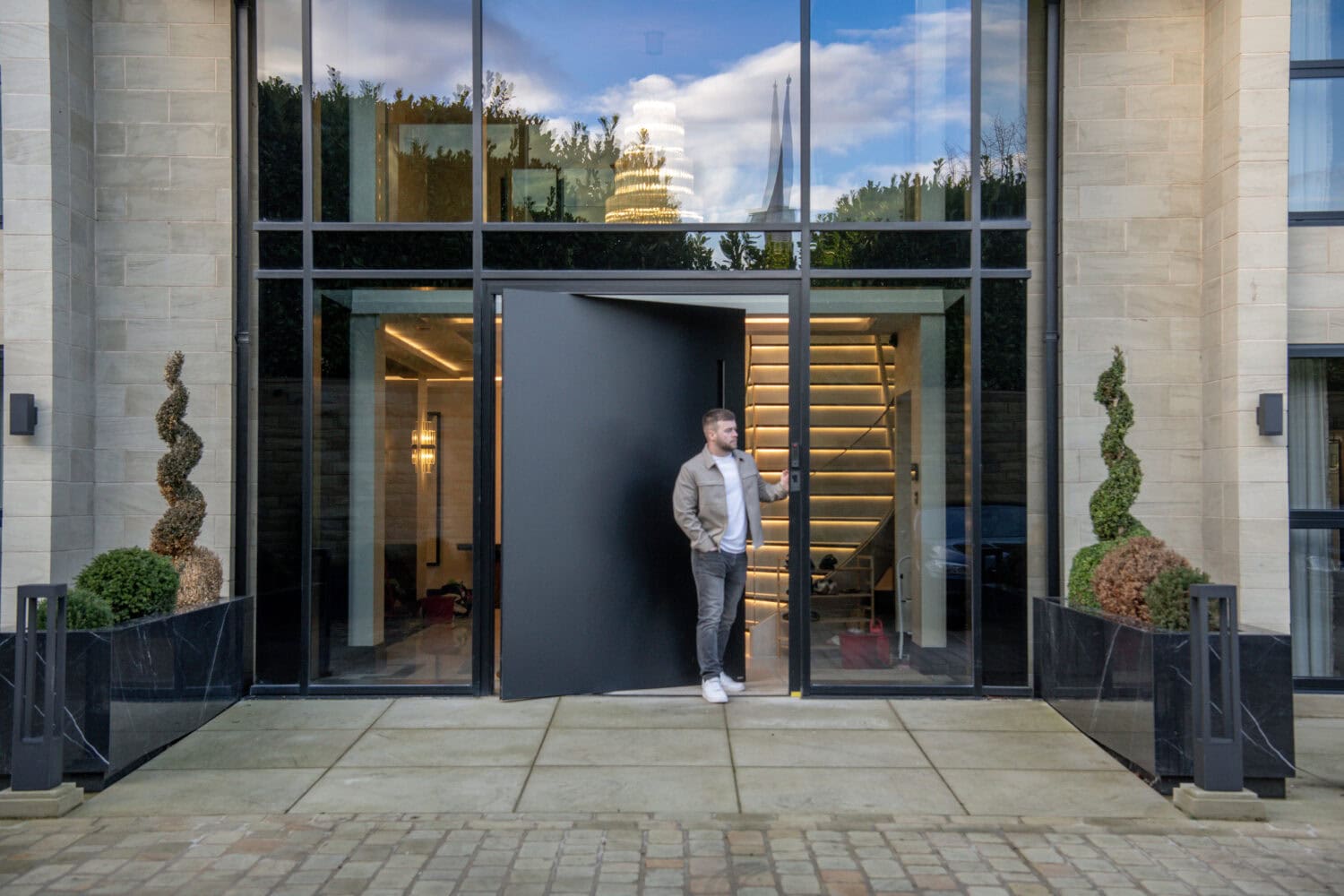 Elegant pivot door opening to a stylish interior with large glass panels and contemporary design. Perfect for enhancing the entrance of modern homes and commercial buildings.
