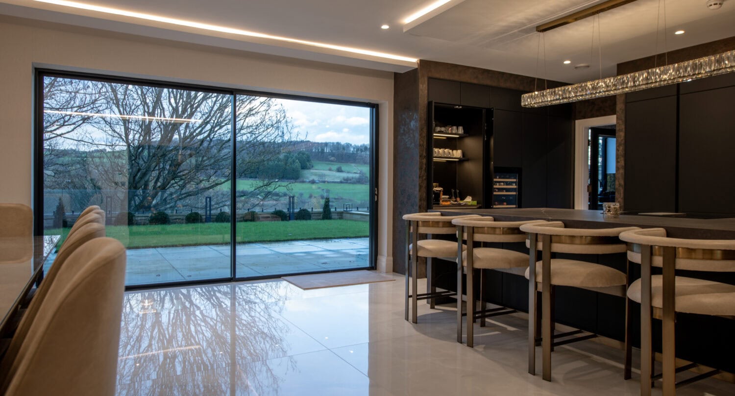 High-quality XP Glide bi-fold doors opening to a scenic outdoor view.
