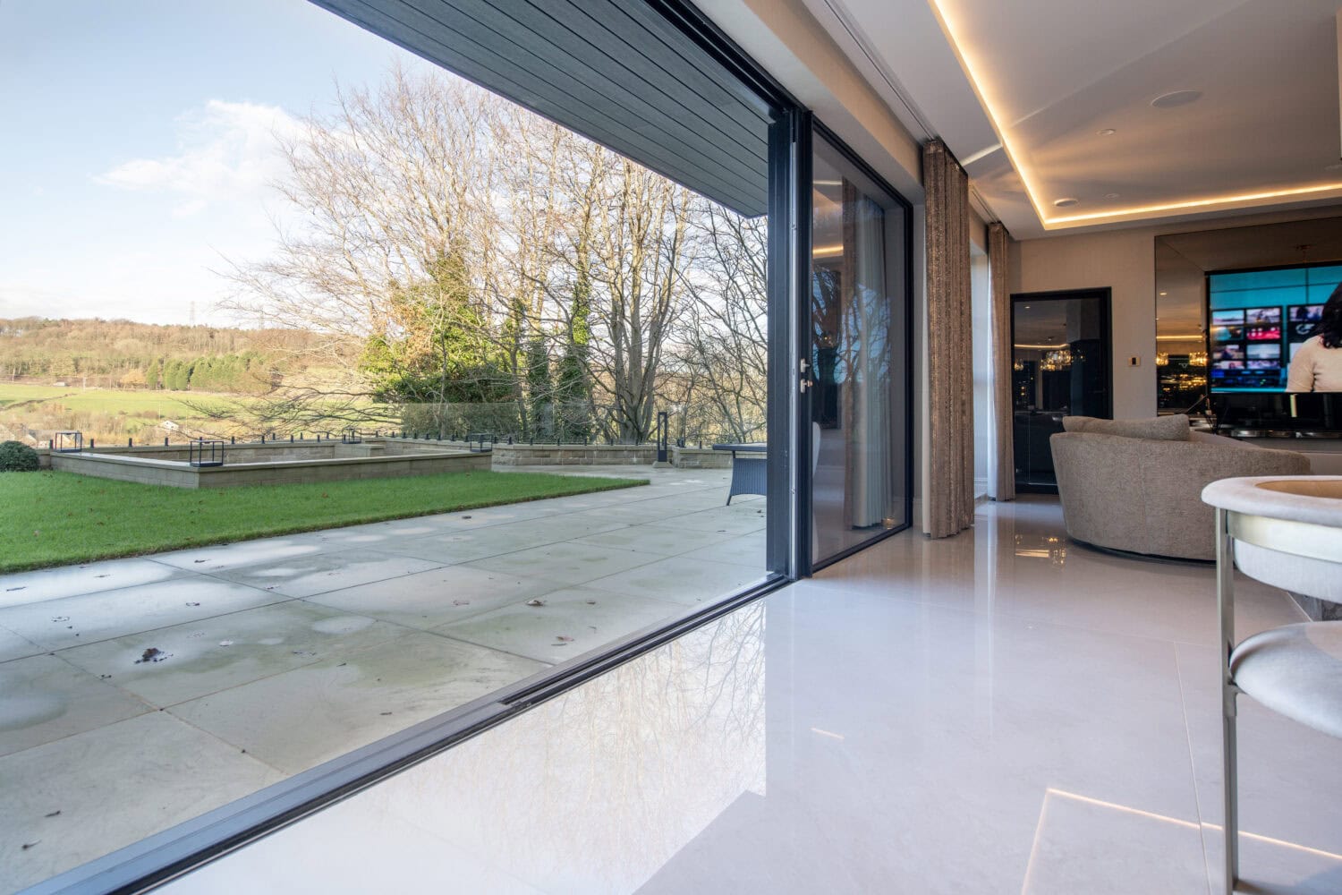 Modern steel look bifold doors opening to a scenic outdoor view, enhancing natural light and space in contemporary interiors. Perfect for stylish, functional home design.