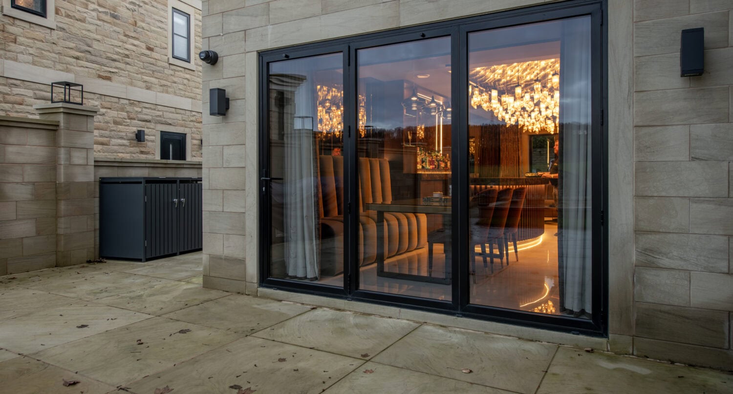 Steel look bi-fold doors with sleek black frames, offering seamless indoor-outdoor living and enhanced security. Perfect for contemporary homes seeking durability and aesthetic appeal.