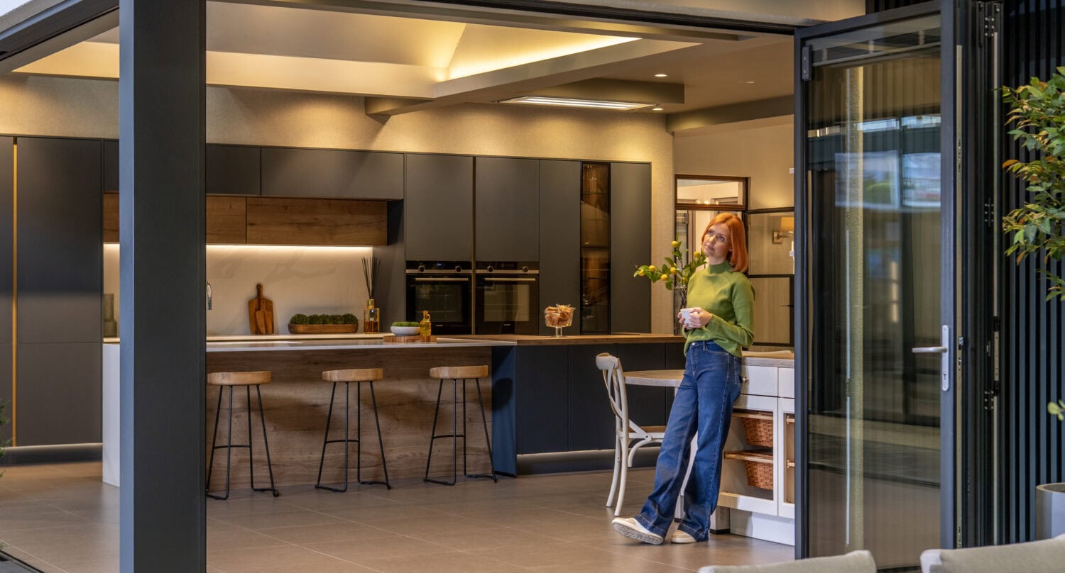 Elegant bi-folding doors opening to a stylish kitchen, showcasing seamless indoor-outdoor living solutions. Perfect for enhancing home aesthetics and functionality.