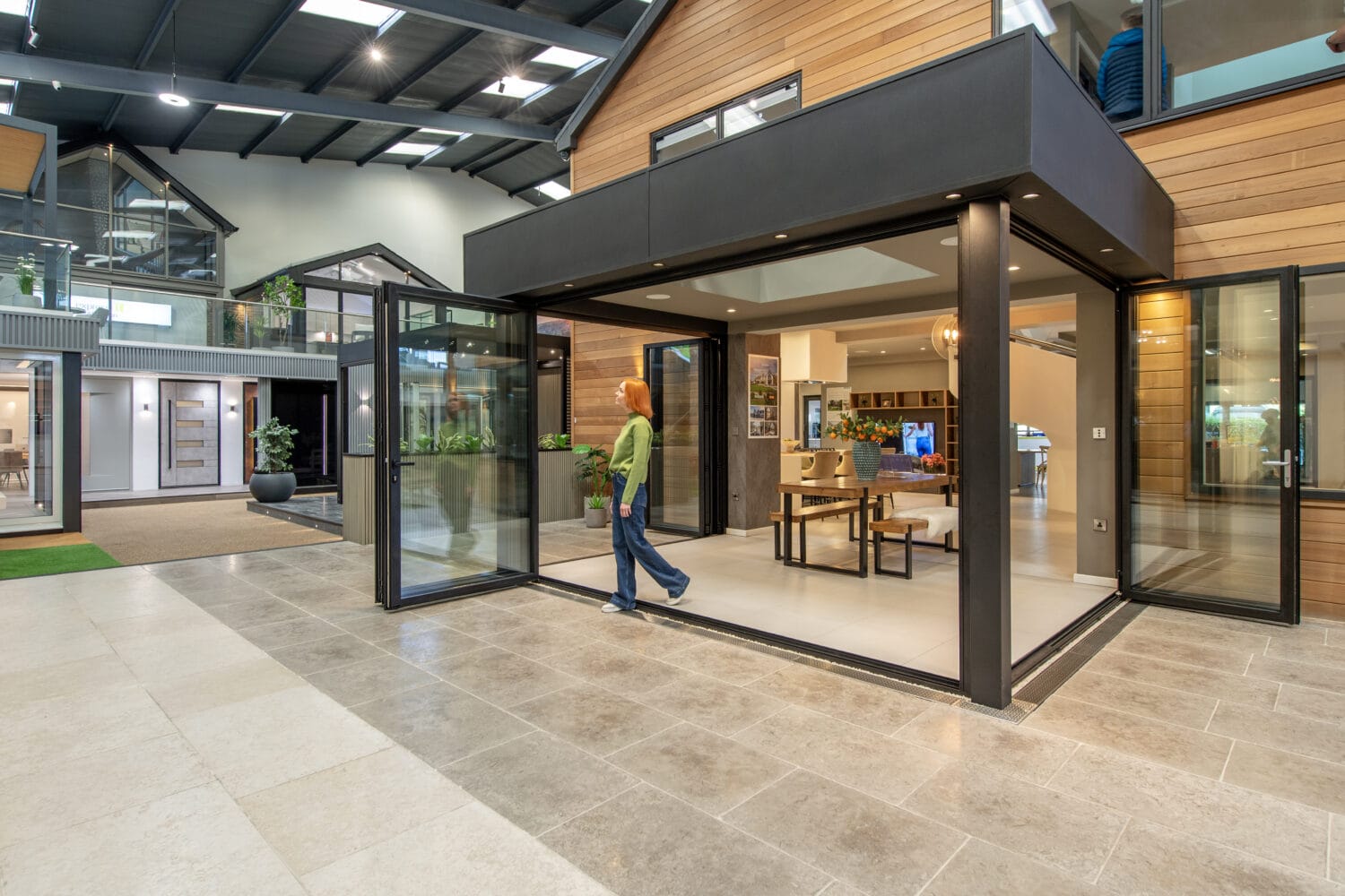 Elegant bi-folding doors opening to a bright, spacious interior at the new Milton Keynes showroom, showcasing high-quality, customisable aluminium bi-folds for seamless indoor-outdoor living.