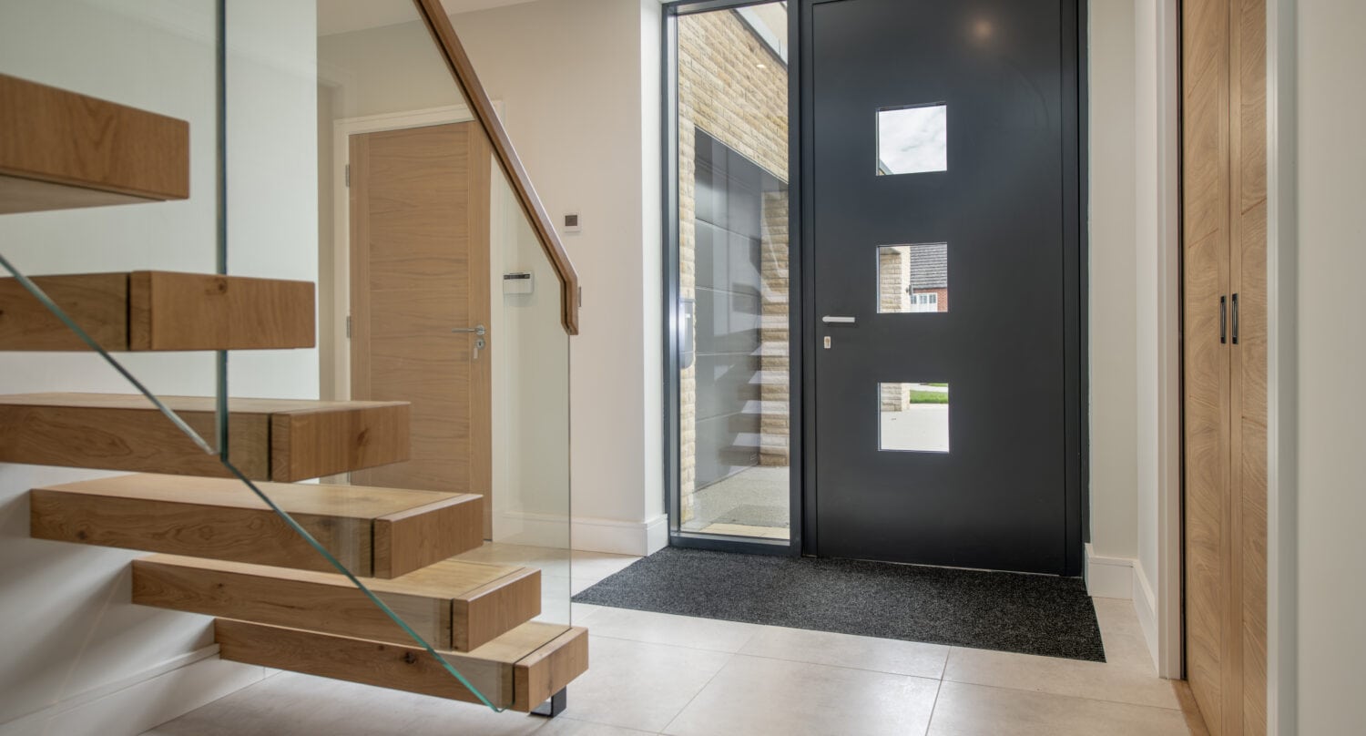 Contemporary black bi-folding door with square glass panels at Chapel Grove, enhancing natural light and modern style. Perfect for stylish home entrances and seamless indoor-outdoor access.