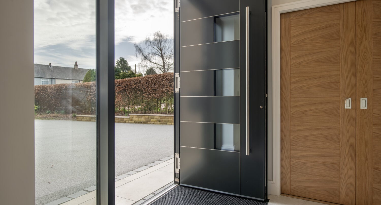 Stylish black bi-folding door opening to outdoor patio, enhancing natural light and indoor-outdoor flow at Chapel Grove residence.