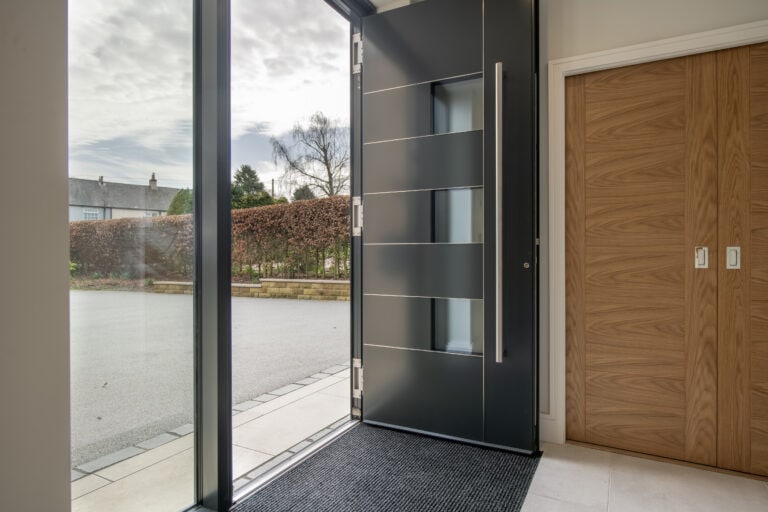 Stylish black bi-folding door opening to outdoor patio, enhancing natural light and indoor-outdoor flow at Chapel Grove residence.