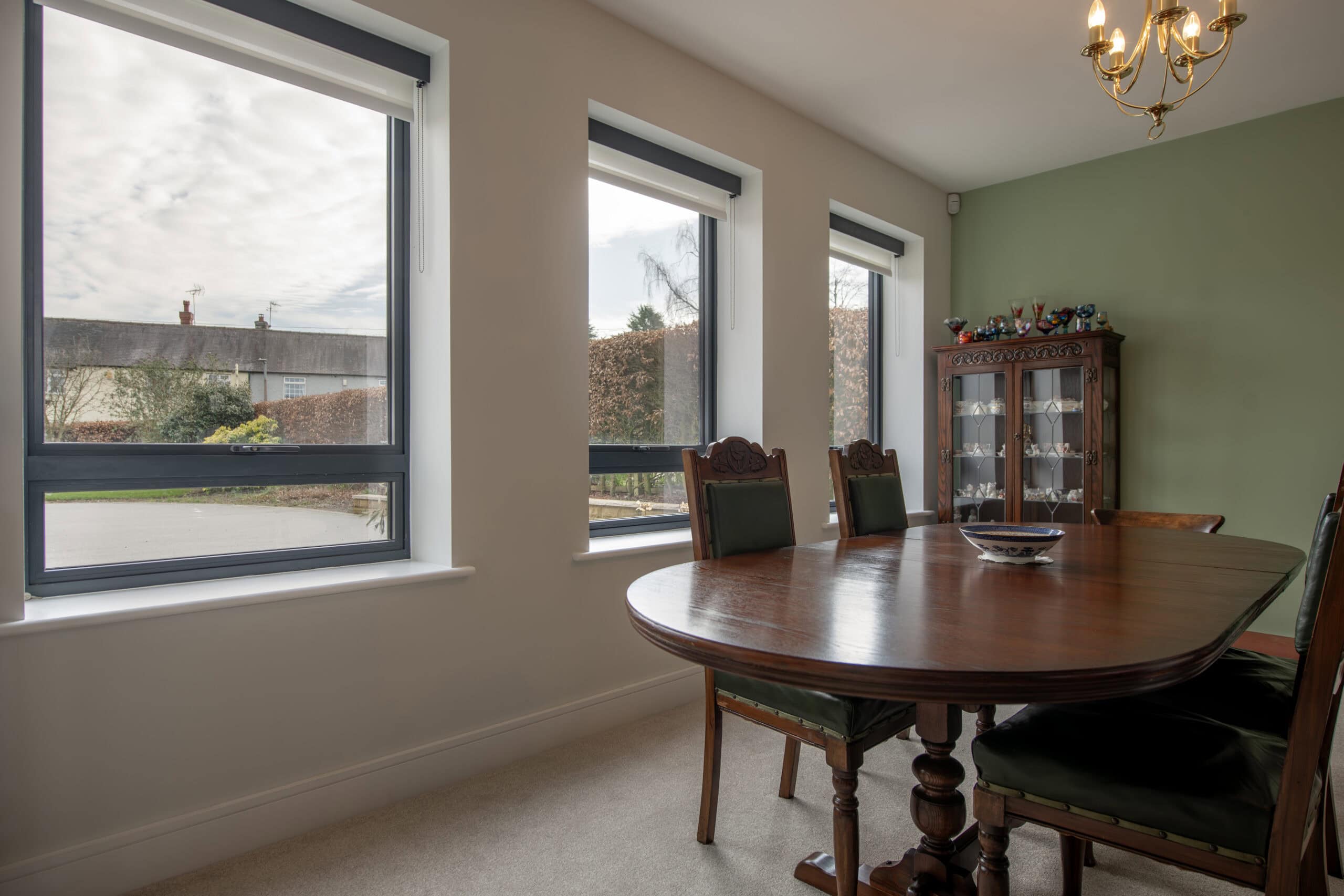 Elegant bi-fold doors installed in a dining room, providing seamless indoor-outdoor access and natural light, ideal for enhancing home aesthetics and functionality.