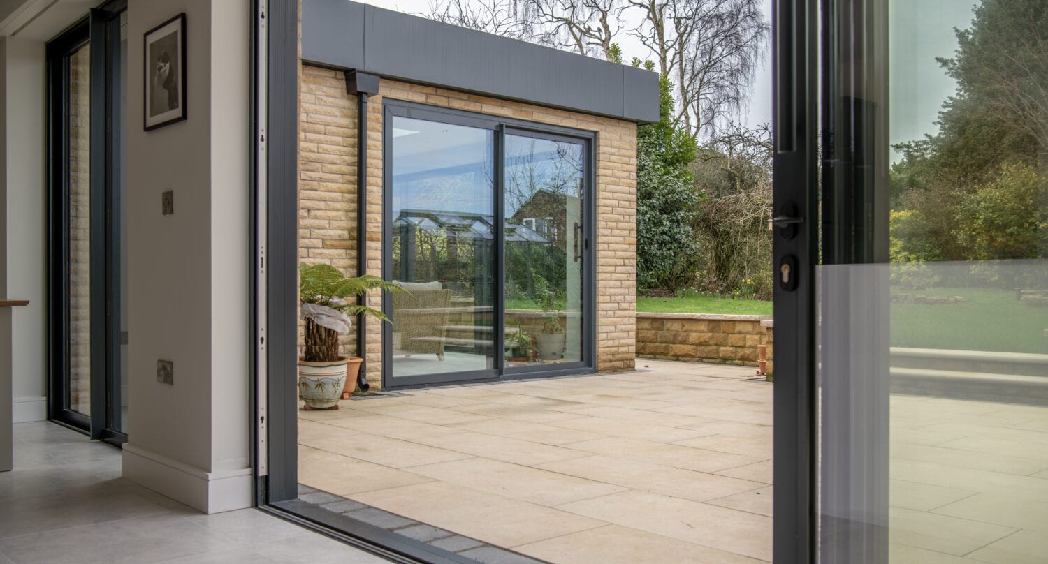 Modern bi-folding doors from Express Bi-Folds at Chapel Grove, offering seamless indoor-outdoor living with stylish, energy-efficient glass panels and durable aluminium frames.