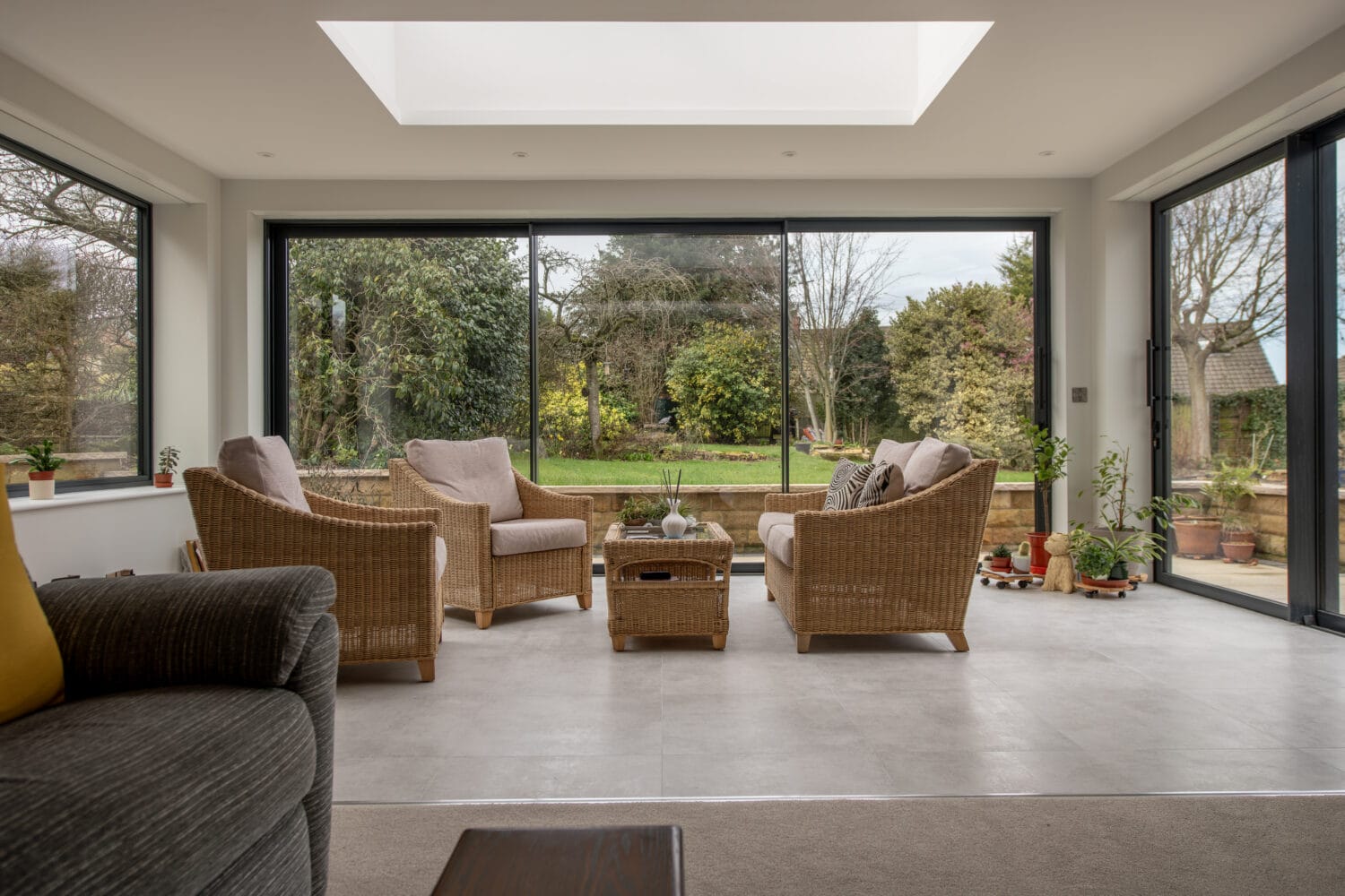 Large glass bi-folding doors at Chapel Grove offering seamless indoor-outdoor living with panoramic garden views and natural light.