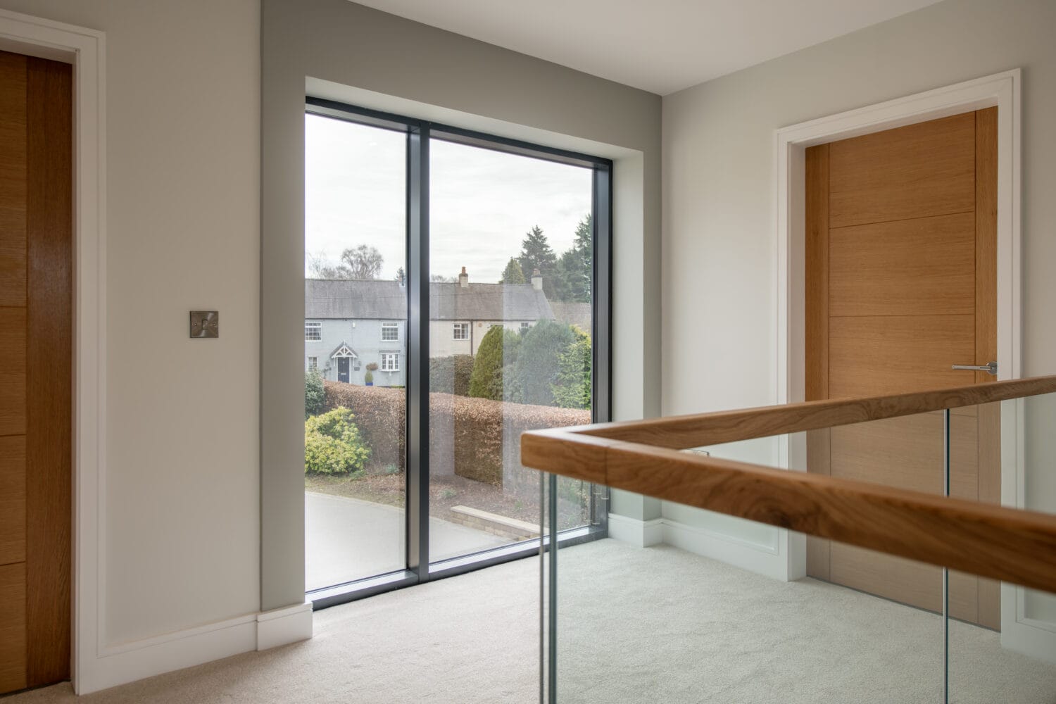 Modern black-framed sliding bi-fold door installed in a bright, contemporary interior, offering seamless outdoor access and enhancing natural light in the Chapel Grove property.