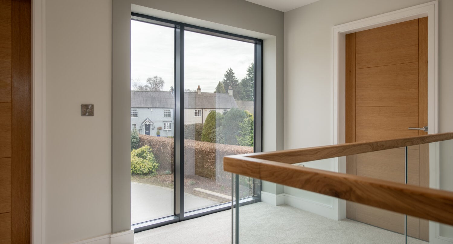 Modern black-framed sliding bi-fold door installed in a bright, contemporary interior, offering seamless outdoor access and enhancing natural light in the Chapel Grove property.