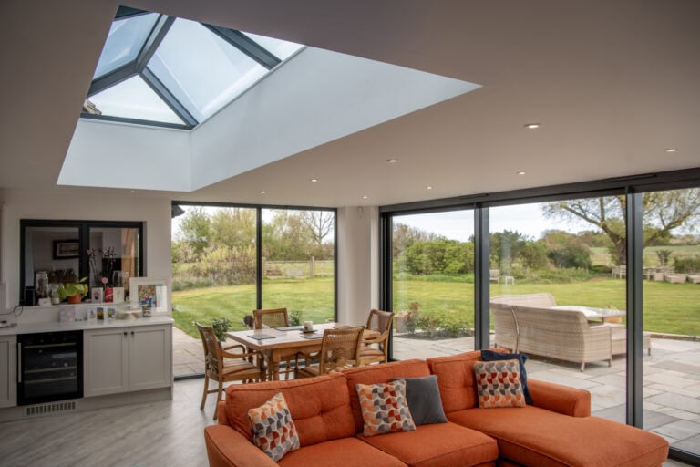High-quality bi-folding doors opening to scenic garden views at Manor House Farm, Buckinghamshire, enhancing natural light and indoor-outdoor living. Perfect for stylish home renovations.