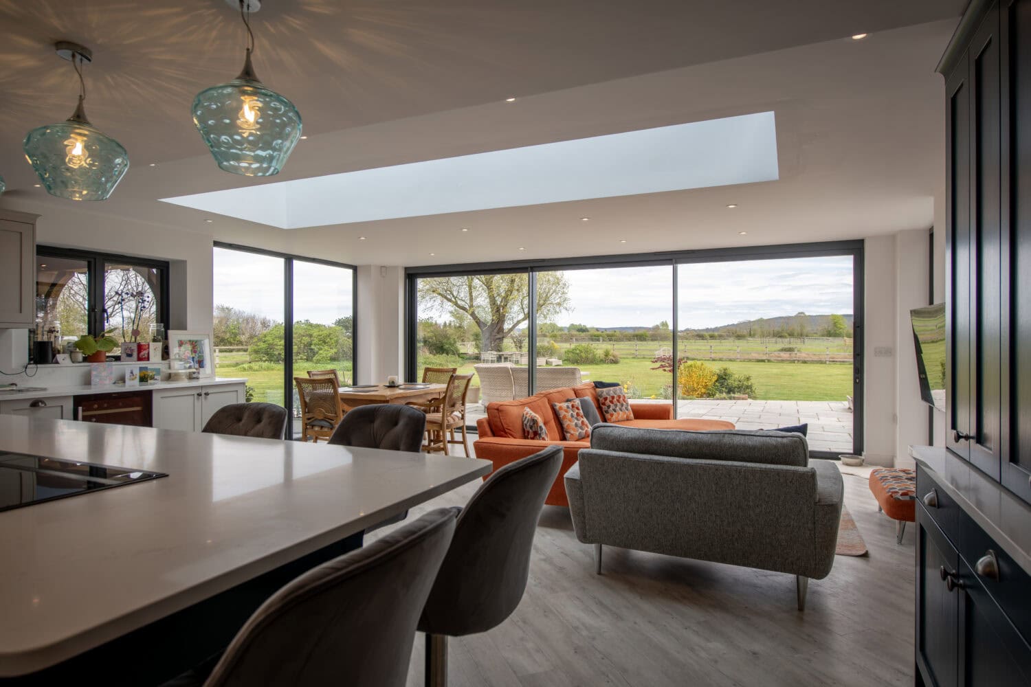 Bi-folding doors opening to scenic countryside views.