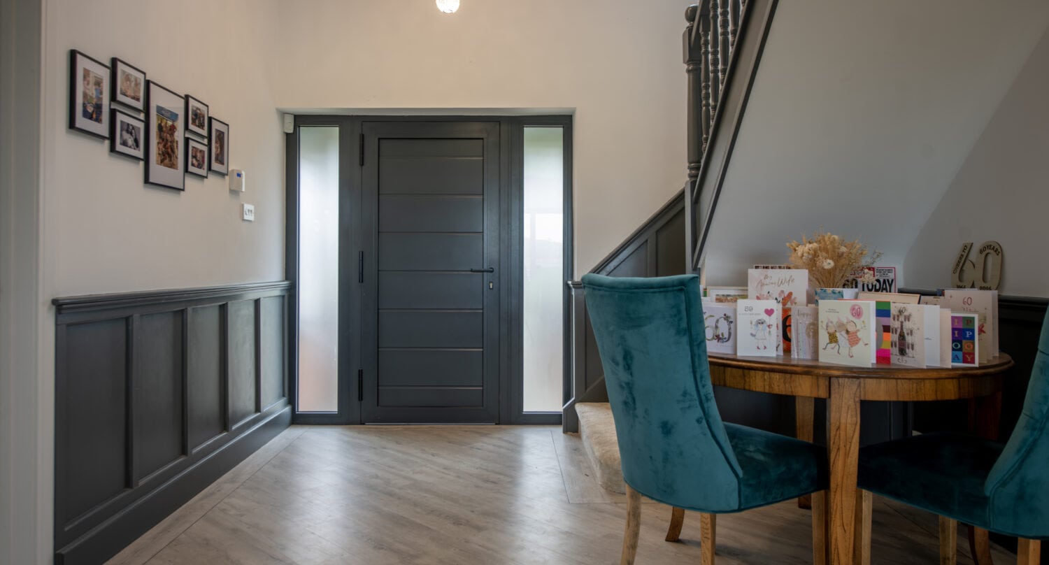 Grey front door with glass panels, leading into a stylish and welcoming home interior. Perfect for enhancing curb appeal and providing security.