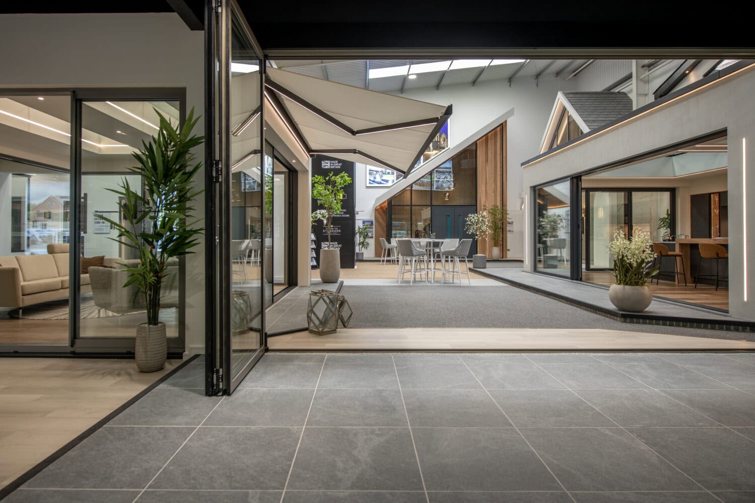 Modern Milton Keynes showroom featuring large bi-folding doors opening to an outdoor patio area, showcasing stylish interior and exterior design.