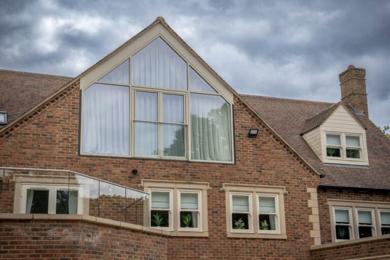 Contemporary house with large glass windows and a glass extension, showcasing modern design and natural light.