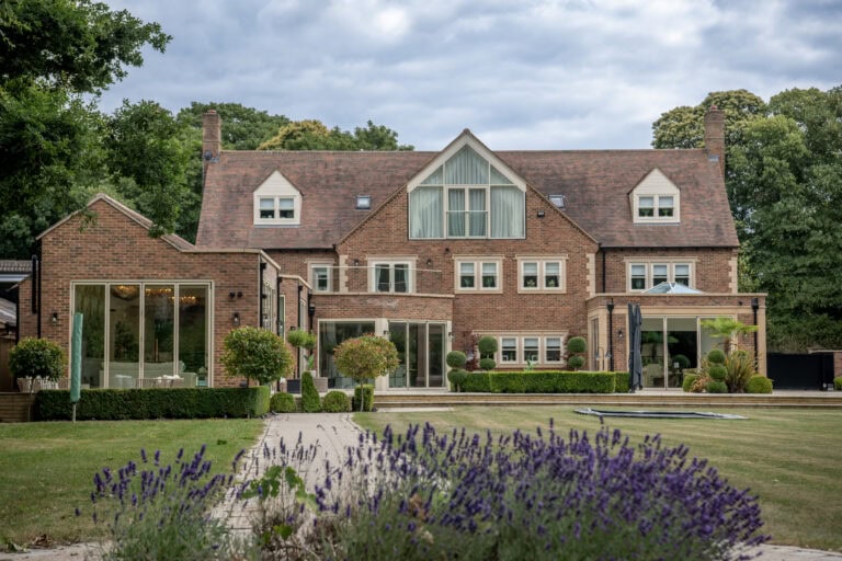 Modern house featuring large bi-folding doors opening to a landscaped garden, showcasing stylish and functional home design.