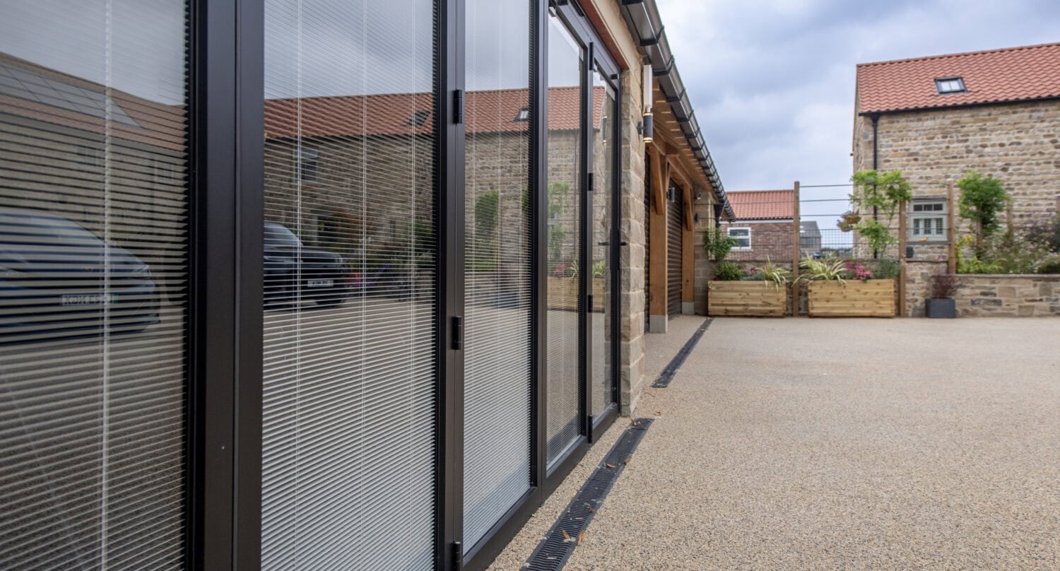 Modern bi-folding doors with glass panels opening to an outdoor patio, enhancing indoor-outdoor living spaces.