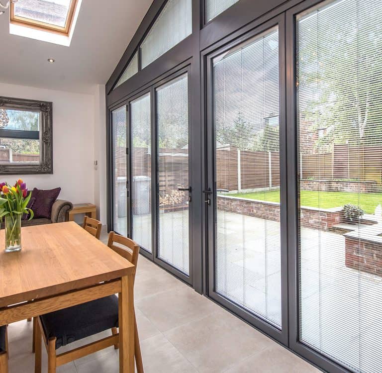 Bi-folding doors with integral blinds in a white dining room