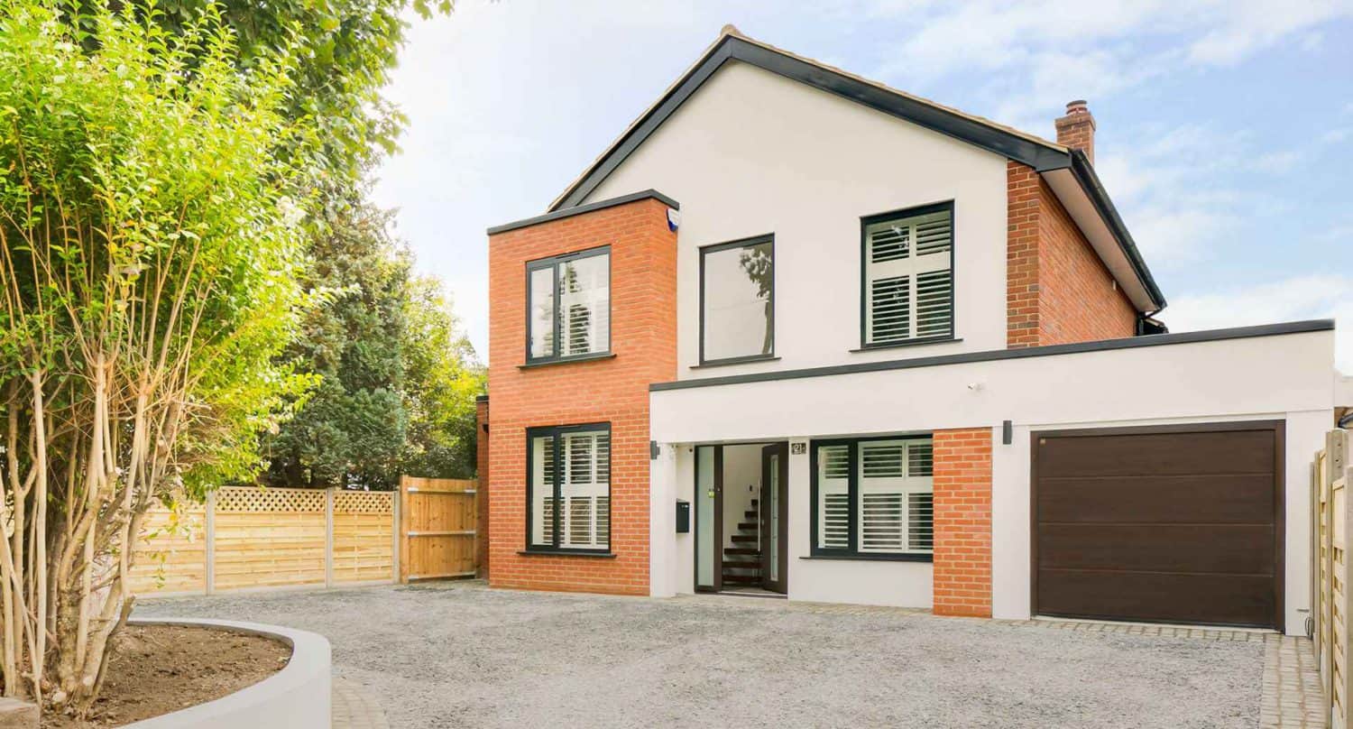 Family home set back from driveway and garage with aluminium casement windows.