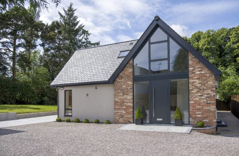 Contemporary bungalow featuring a grey front door with side panels