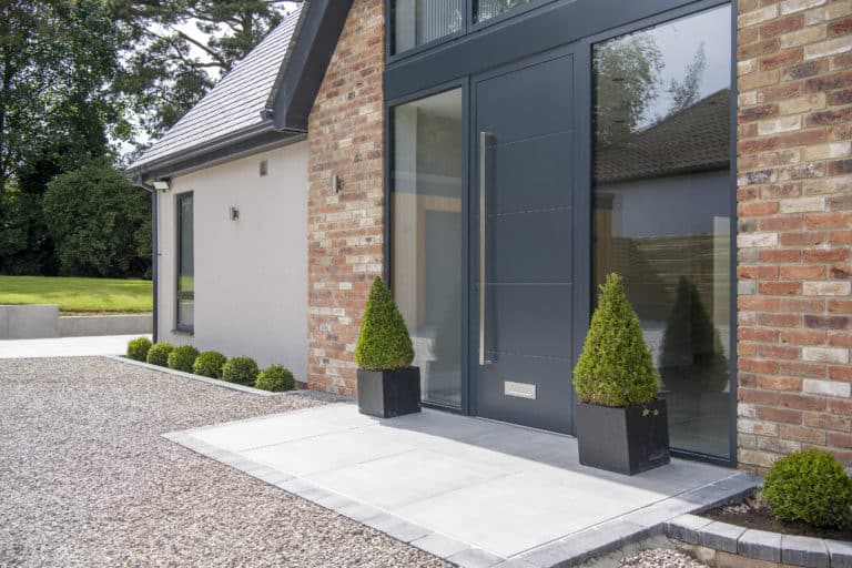 Modern anthracite grey front door with long handle and glass side panels