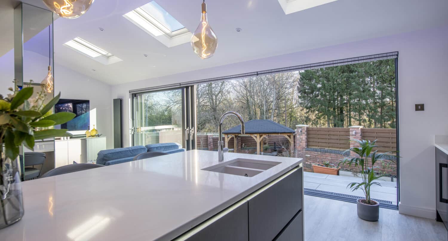 Kitchen extension featuring an island and sliding aluminium glass doors