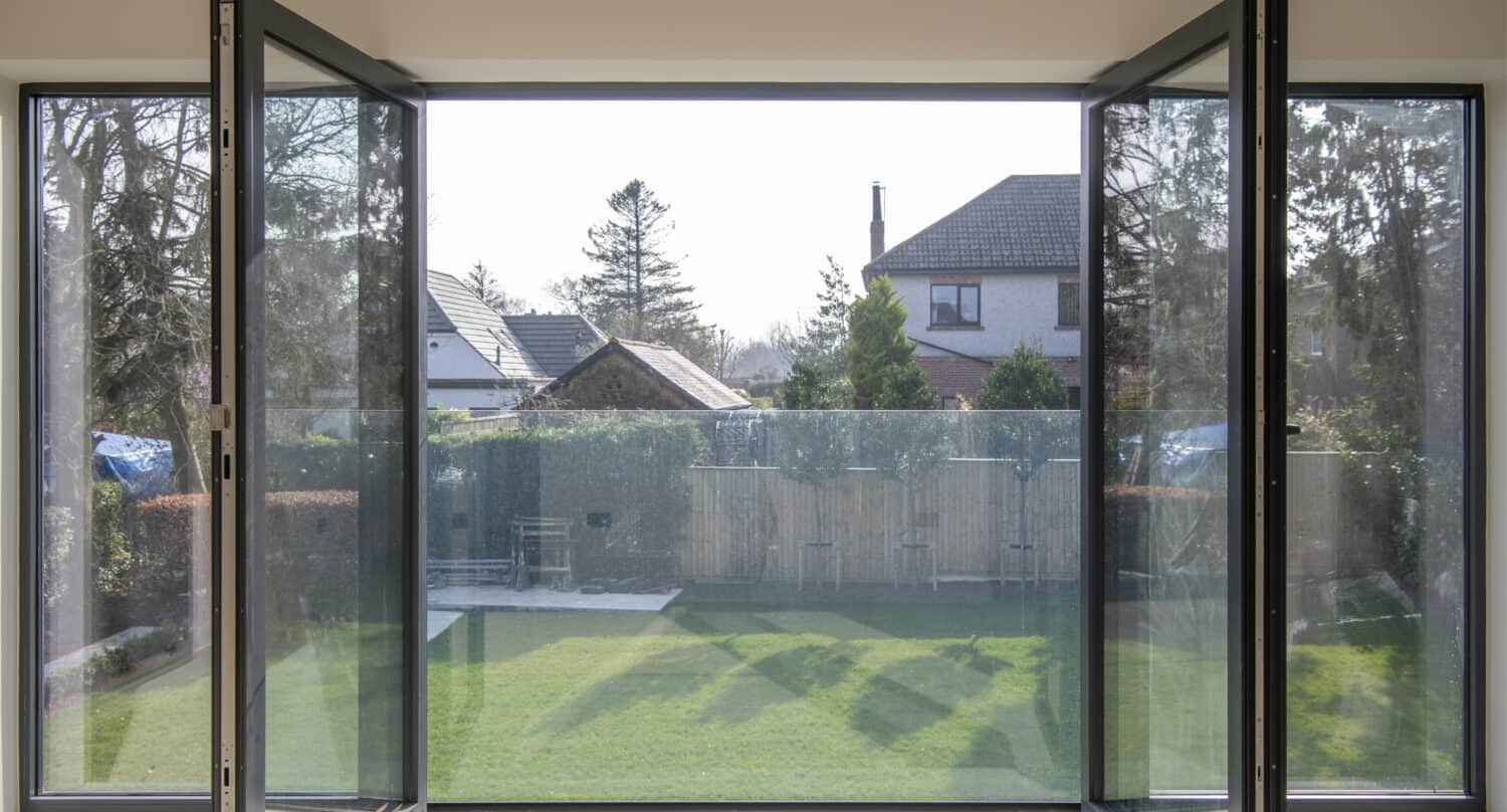 Open bespoke anthracite windows looking out on family garden