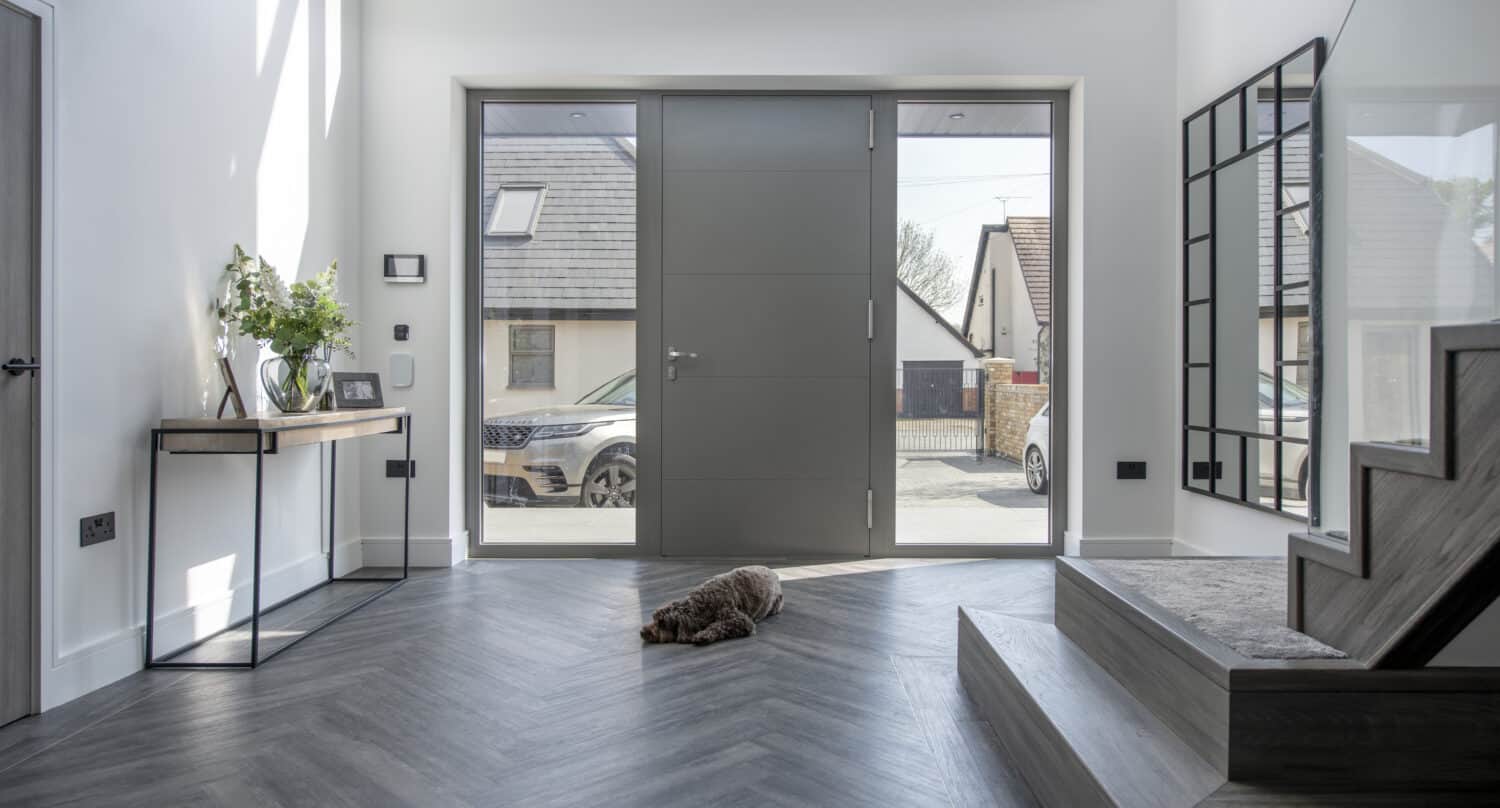 Modern hallway featuring a linear 4 panel aluminium front door with sidelights