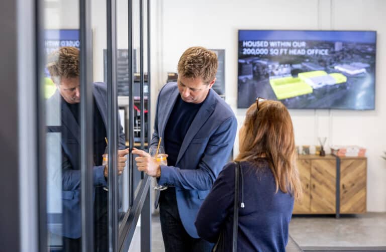 A man and a lady taking a close look to aluminium windows in a showroom
