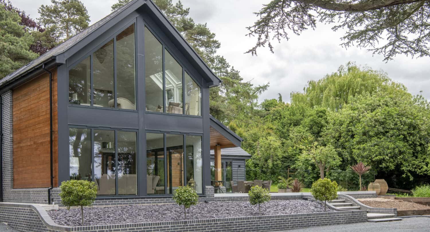 Luxury home featuring black curtain walling, bifolding doors and balustrade glass in the patio area