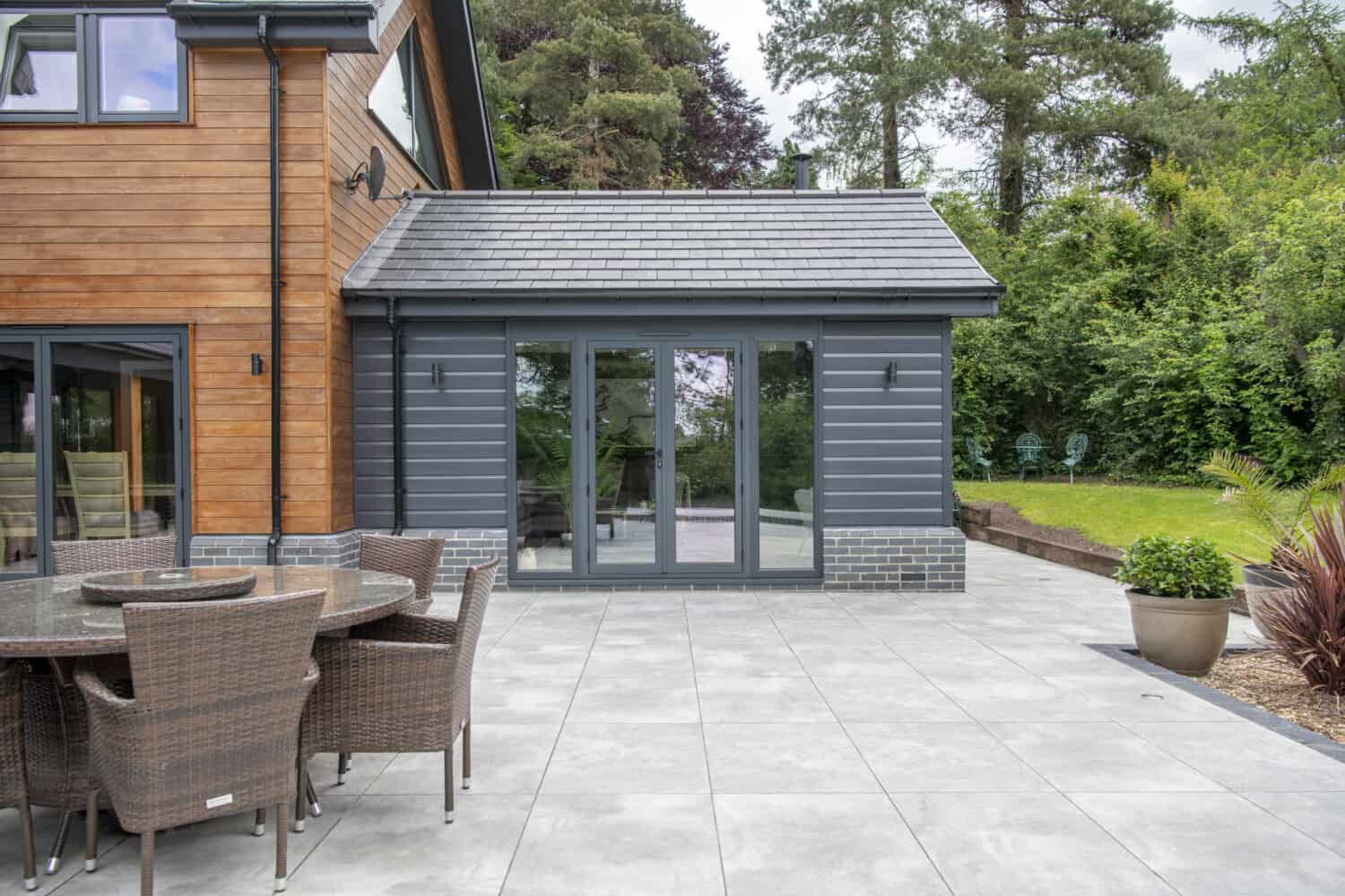 Small single story extension featuring black patio doors with side panels