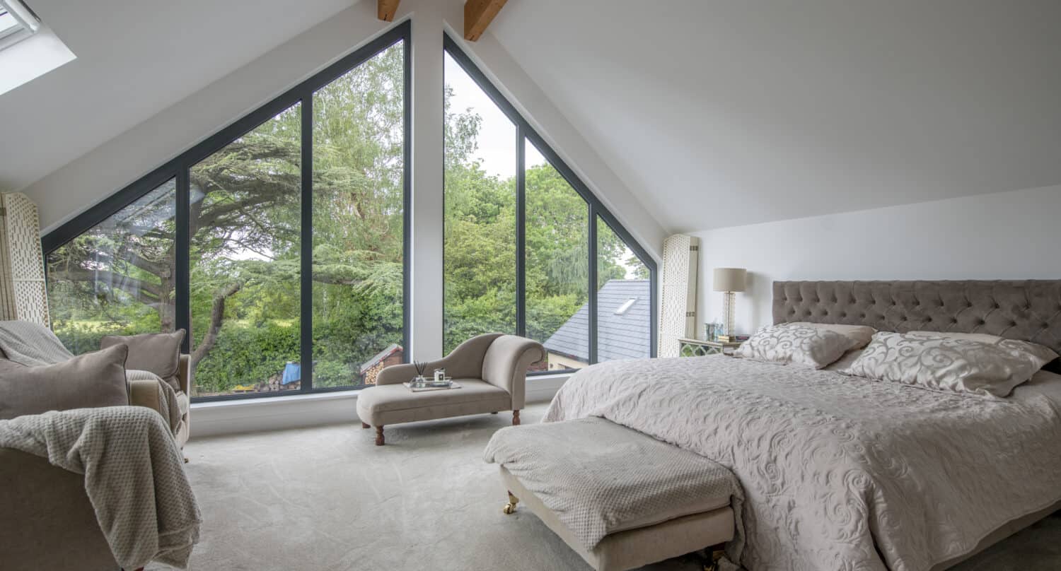 Luxury master bedroom featuring two big aluminium shaped windows