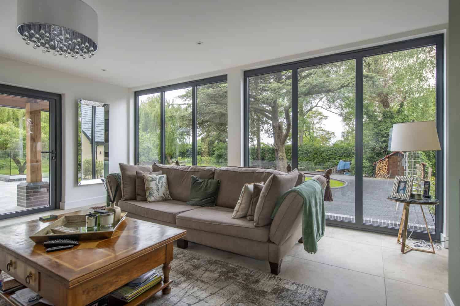 Modern living room space featuring a brown sofa and two sets of three panel windows