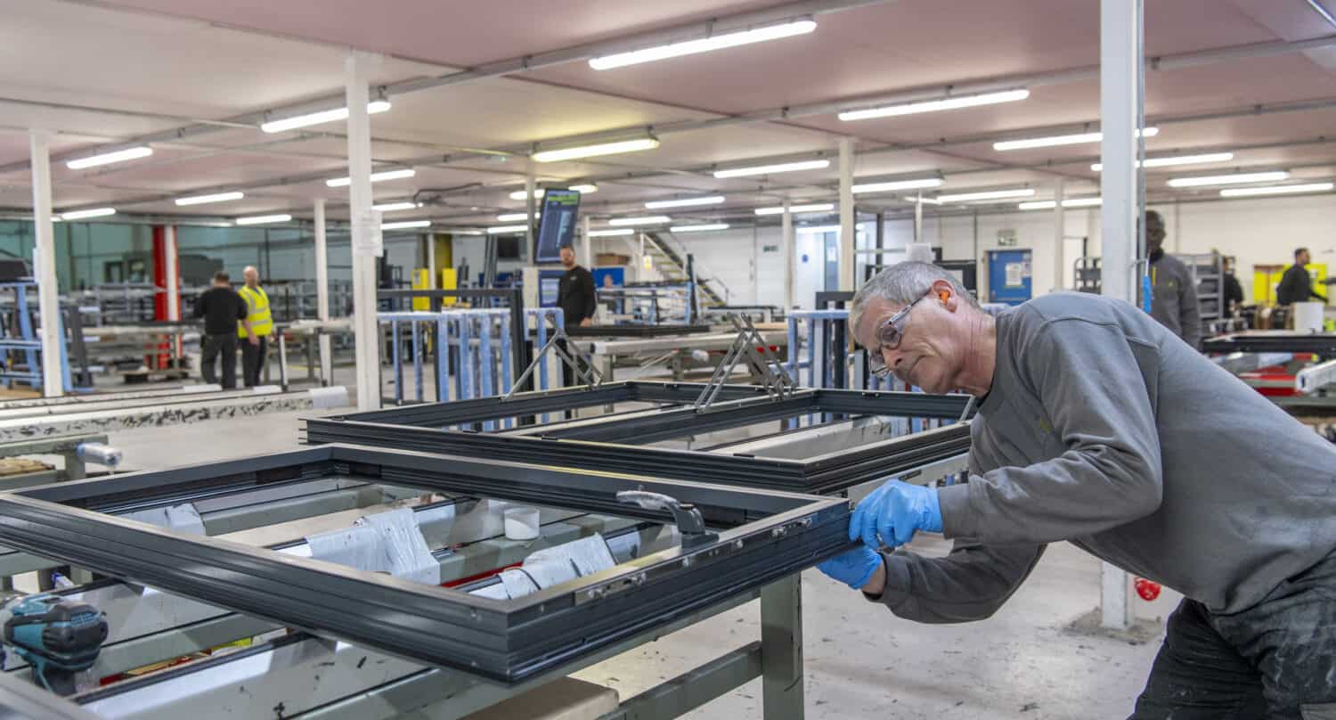 Technician working on an aluminium window in a manufacturing warehouse