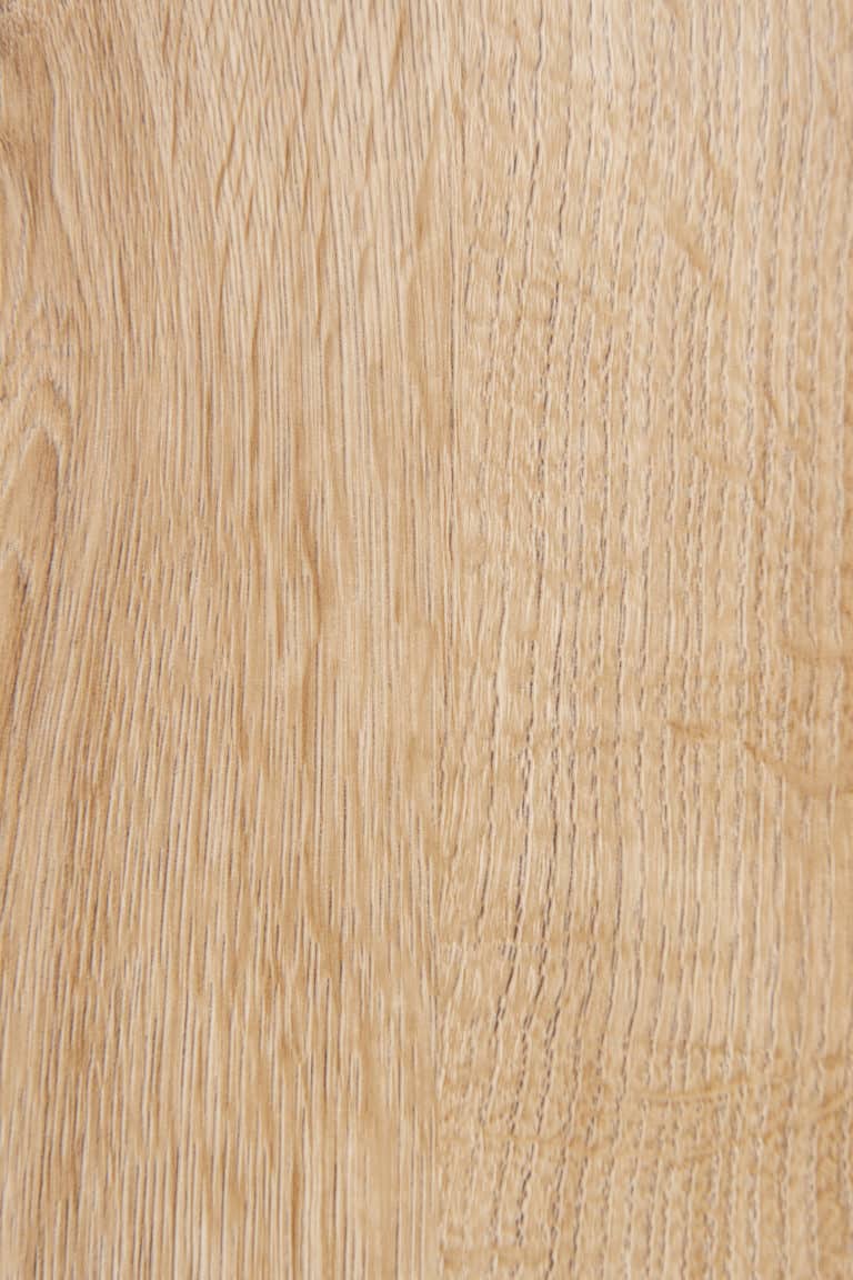 Close-up of a light brown wooden surface showing natural grain patterns and texture—an elegant pairing for bespoke glass solutions like bifold doors or glass roofing, with the wood’s smooth finish enhancing any modern architectural design.