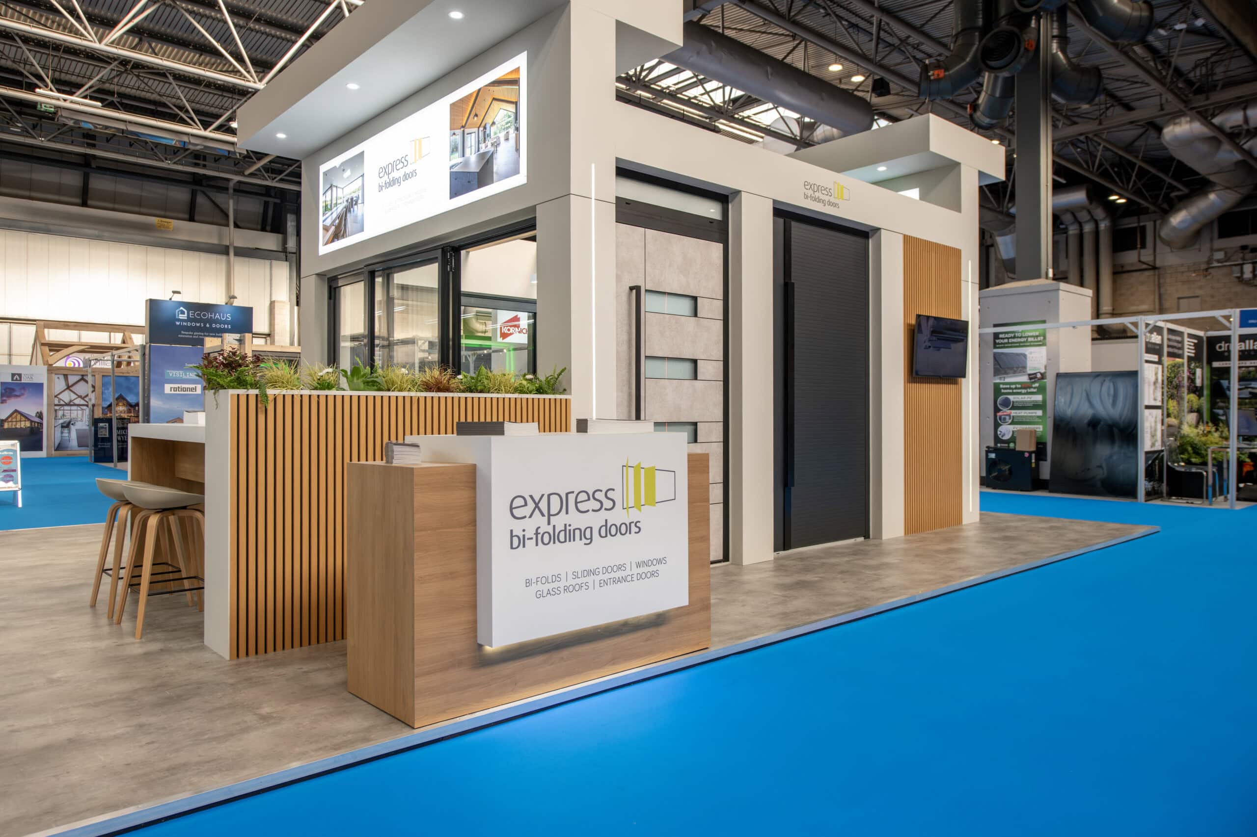 Modern exhibition stand showcasing Express Bi-Folding Doors at a trade event, featuring sleek door designs and branding for upcoming industry exhibitions.