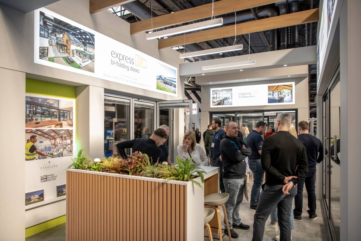 Showcasing modern bi-folding doors at the Express Bi-Folding Doors exhibition with visitors exploring the latest designs and features.