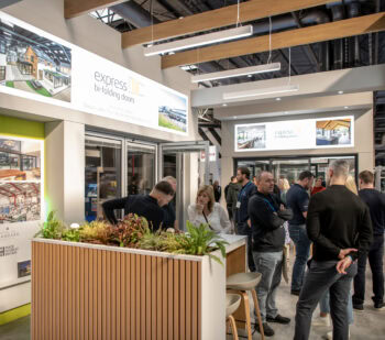 Showcasing modern bi-folding doors at the Express Bi-Folding Doors exhibition with visitors exploring the latest designs and features.